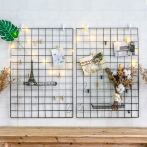 Wall-mounted wire grids adorned with fairy lights.